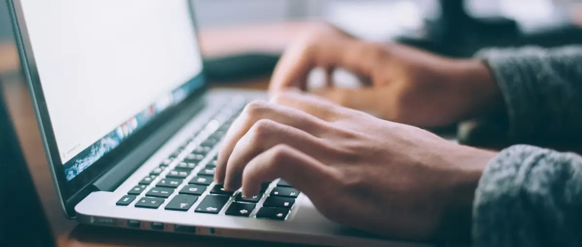 A closeup of someone working on two computers.