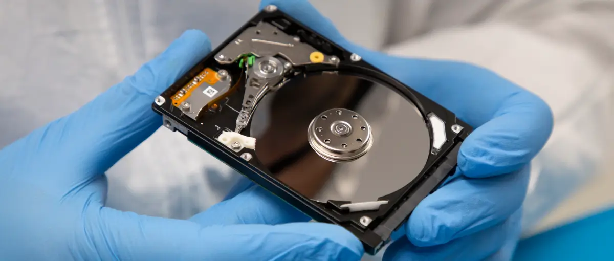 Data recovery engineer holding a broken hard drive