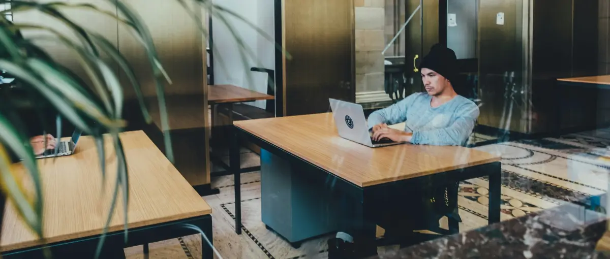 Person on computer in open office space.