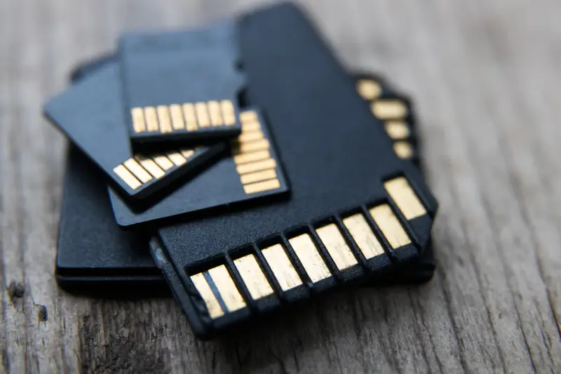 A pile of SD cards and microSD cards on a table.