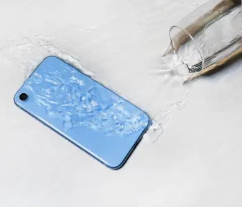 A glass of water spilled on a smartphone.