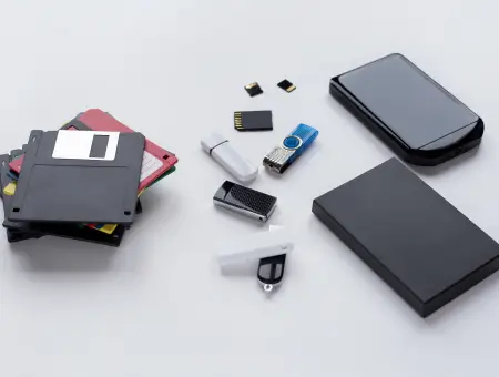 An image of a collection of removable storage, including external hard drives, media cards, flash drives, and floppy disks.